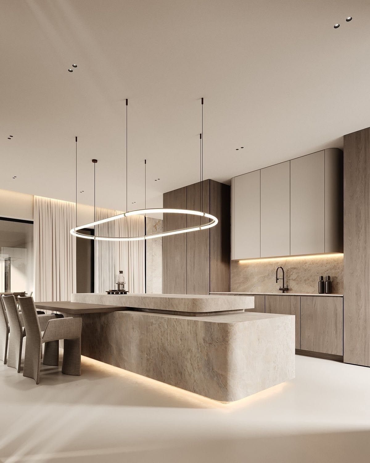 Warm travertine kitchen with a waterfall island and oval ring pendant