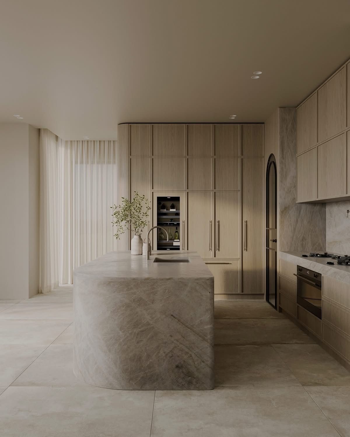 The Carlton Kitchen with a rounded-end stone island and pale oak cabinetry